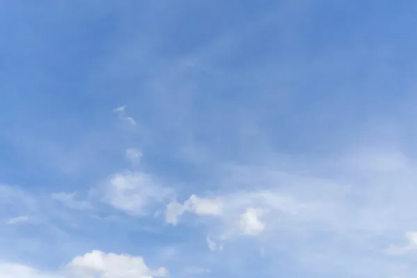 Blue sky with scattered white clouds.